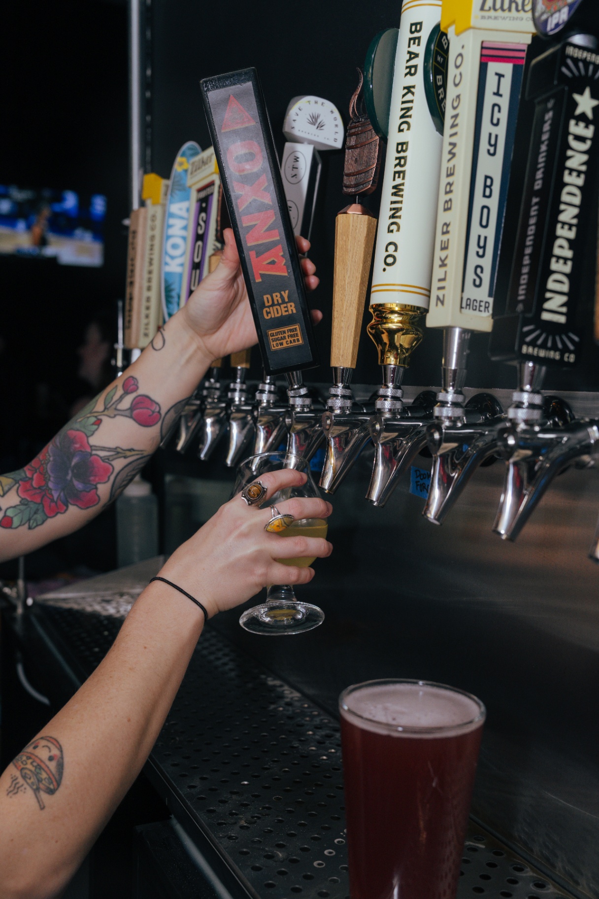 Bartender pouring a beer at the tap wall