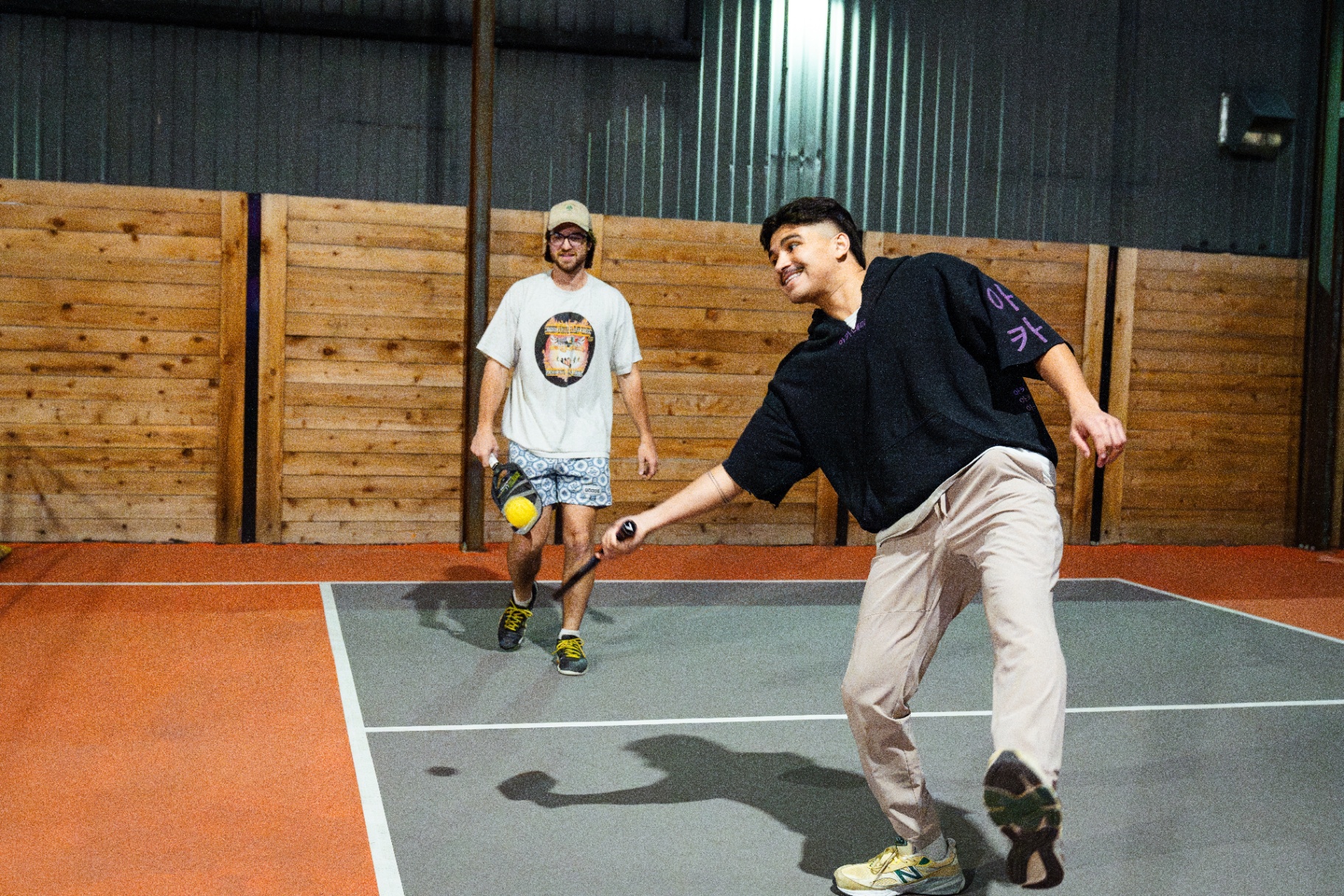 Player laughing mid-point on the indoor court