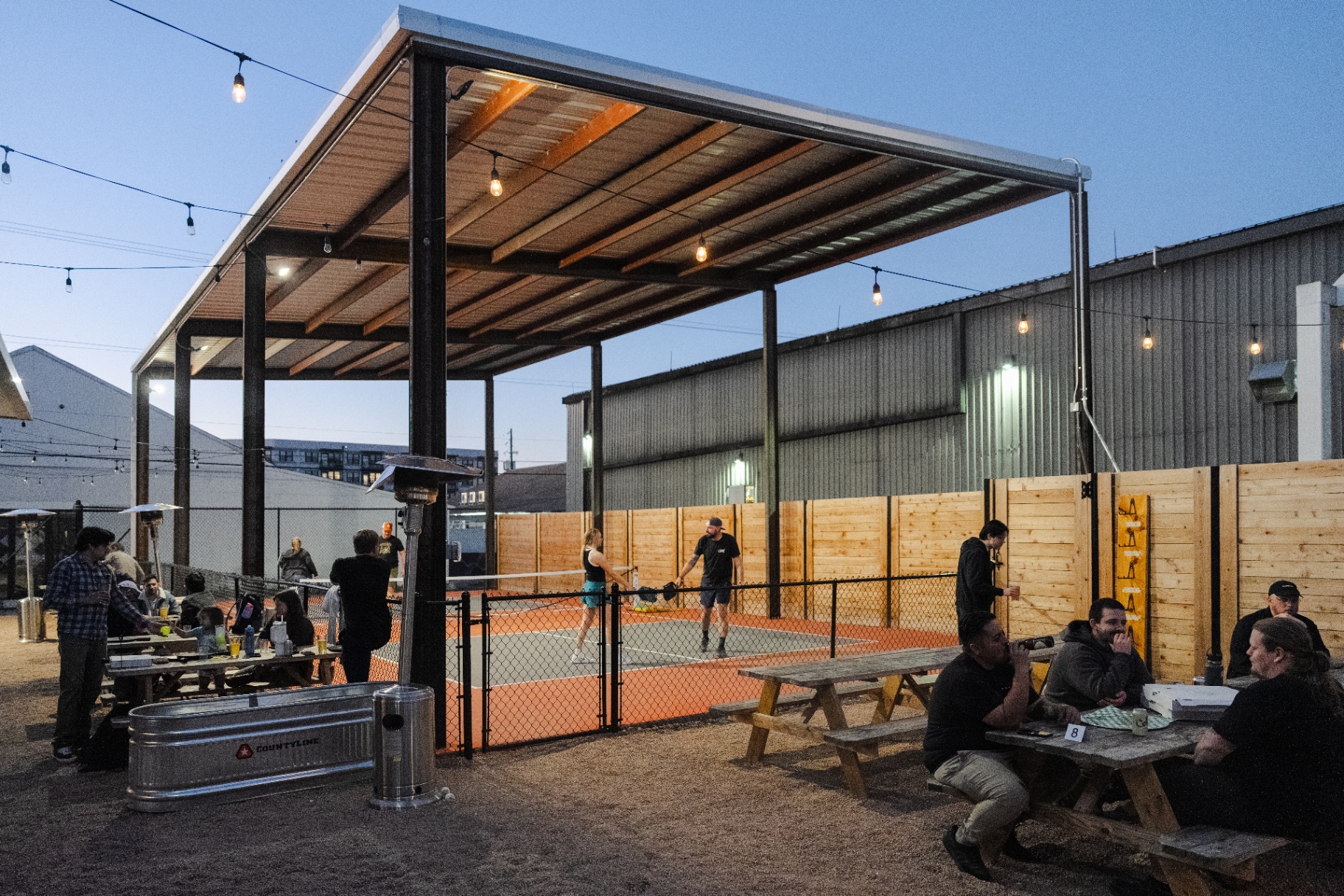 Outdoor pickleball court at dusk at Ants Beer Cave